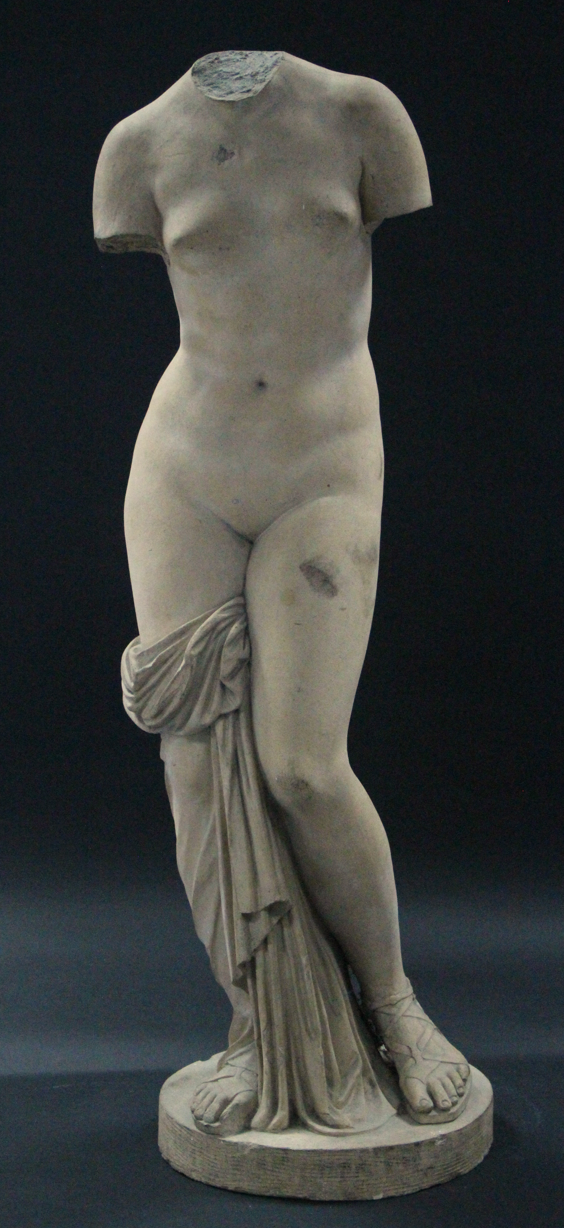 A reconstituted stone classical female nude figure, on flat circular base; 34¾” high.