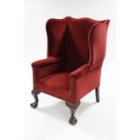 An 18th century-style wing back armchair upholstered brass-studded crimson velour, with sprung seat,