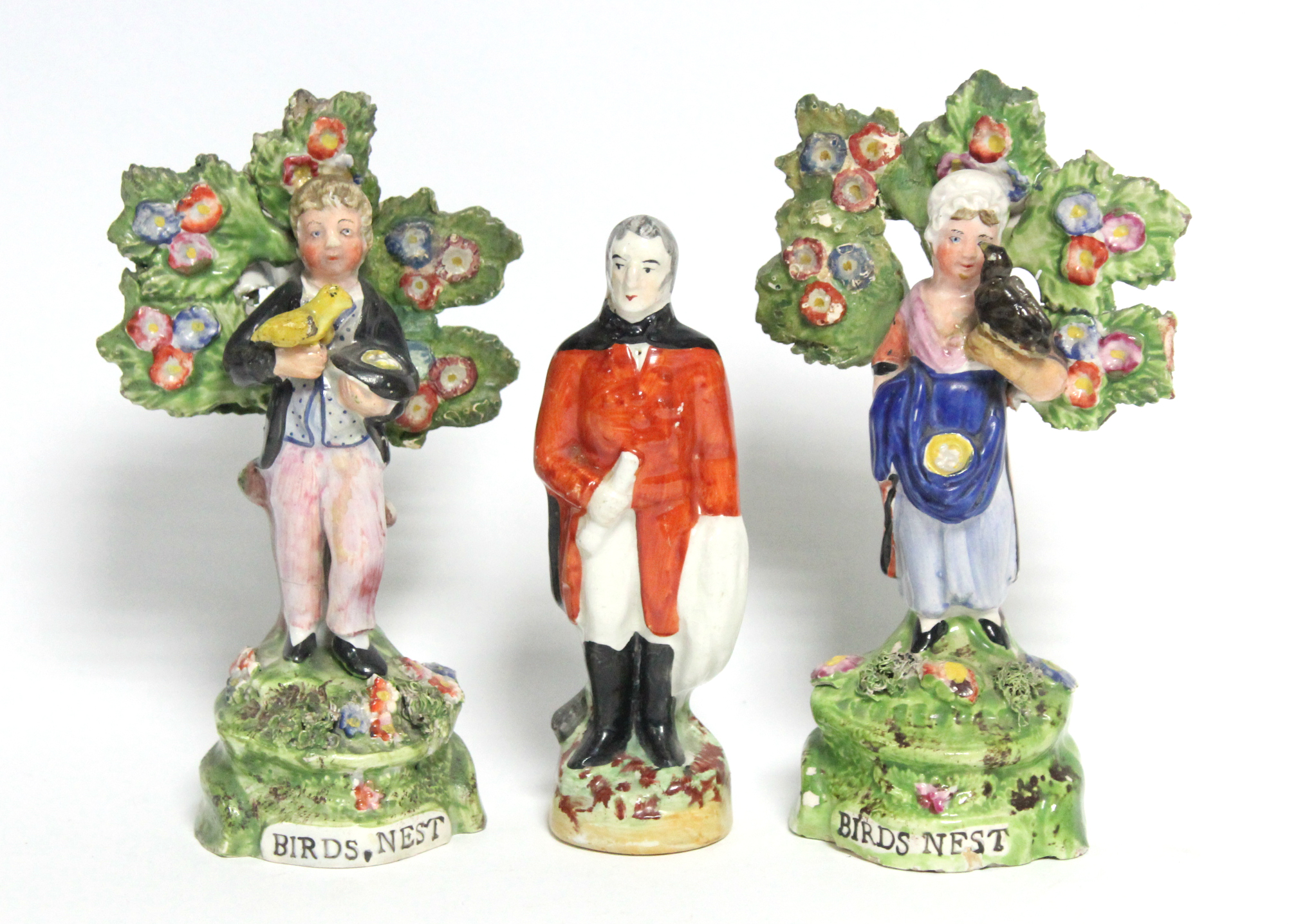 A pair of early 19th century Staffordshire pottery male & female standing bocage figures, each
