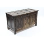 A late 17th century oak coffer, the triple-panel front with later carved floral decoration, with