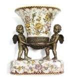A Toussi Court flared oval vase supported by two gilt-brass cherubs, on rectangular ceramic base,