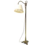 An Edwardian brass standard lamp with scroll arm, on triform base with lion-paw feet; 5'6" high; & a