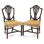 A pair of 18th century mahogany Hepplewhite-style dining chairs, the shield-shaped backs with