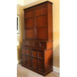 A 19th century mahogany tall cabinet, the upper part fitted four adjustable shelves enclosed by a