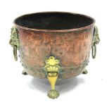 A 19th century copper log vase with brass lion-mask & ring side handles & splay claw feet; 17¾" wide