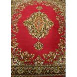 An Axminster-type Persian pattern carpet of crimson ground central medallion surrounded by floral