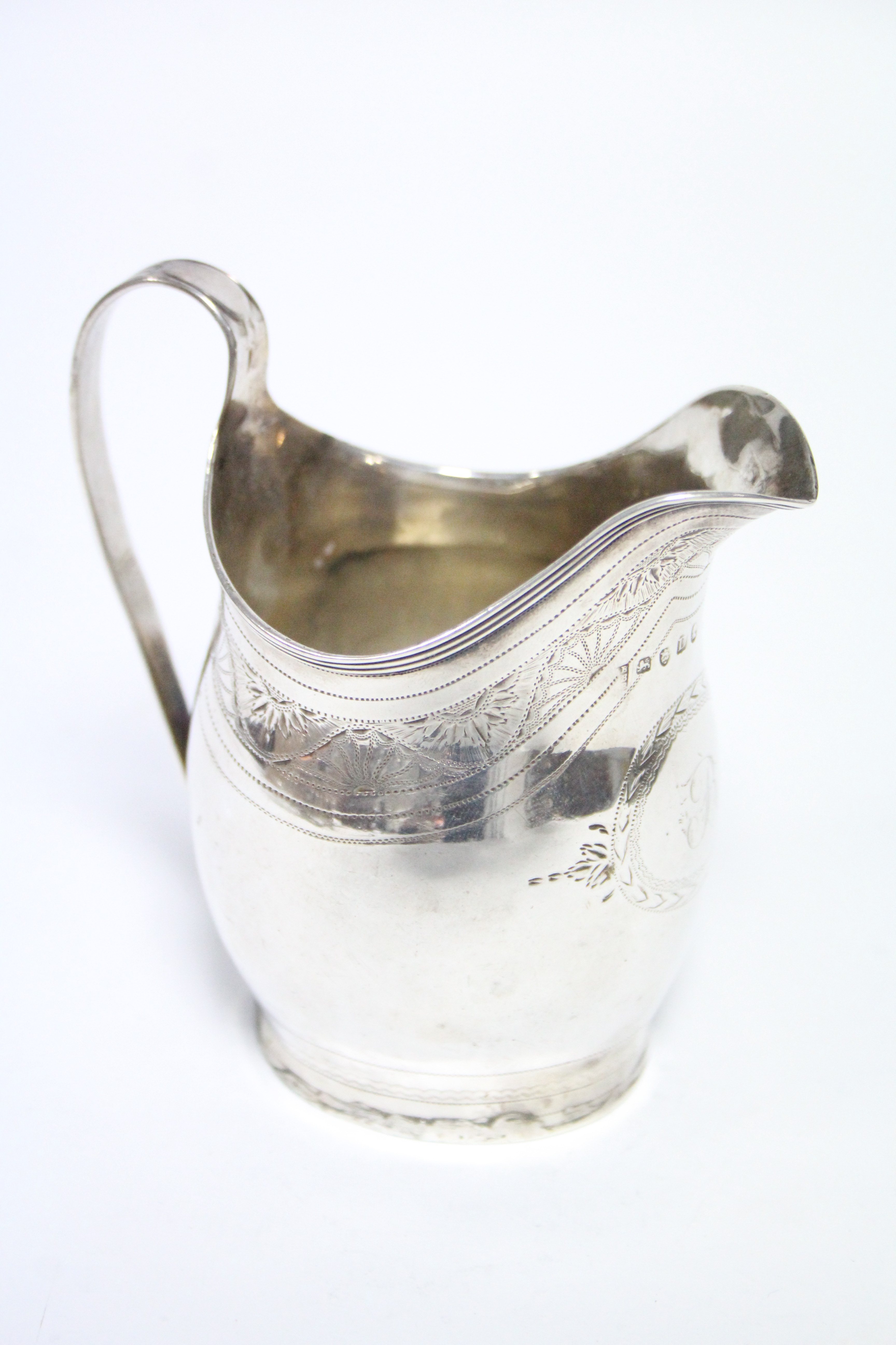 A George III upright ovoid milk jug with engraved decorative bands, reeded rim, & loop handle, 4¼”