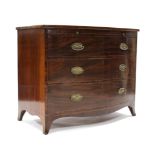 An early 19th century mahogany bow-front chest fitted brushing slide above three long graduated