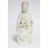 An 18th century Chinese blanc-de-chine figure of Guanyin, seated, with an infant on her lap; 10”