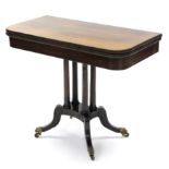 A regency rosewood card table with gadrooned edges to the fold-over top, on four slender turned