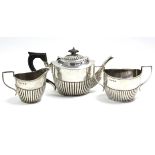 A late Victorian oval semi-fluted three-piece tea service; Birmingham 1892-3, by Barker Bros. (23