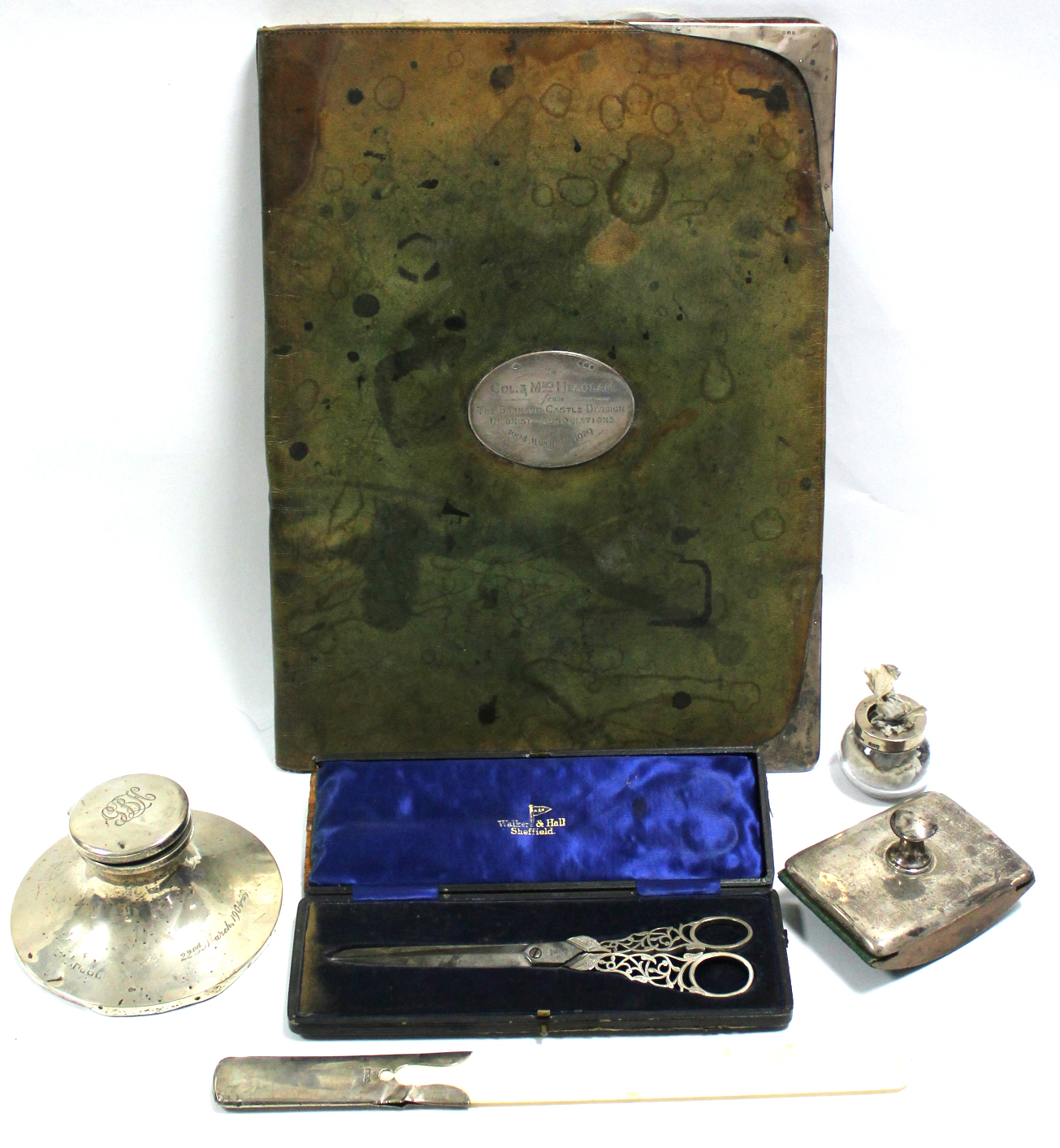 A capstan inkwell with engraved inscription; a silver-mounted large rectangular leather blotter