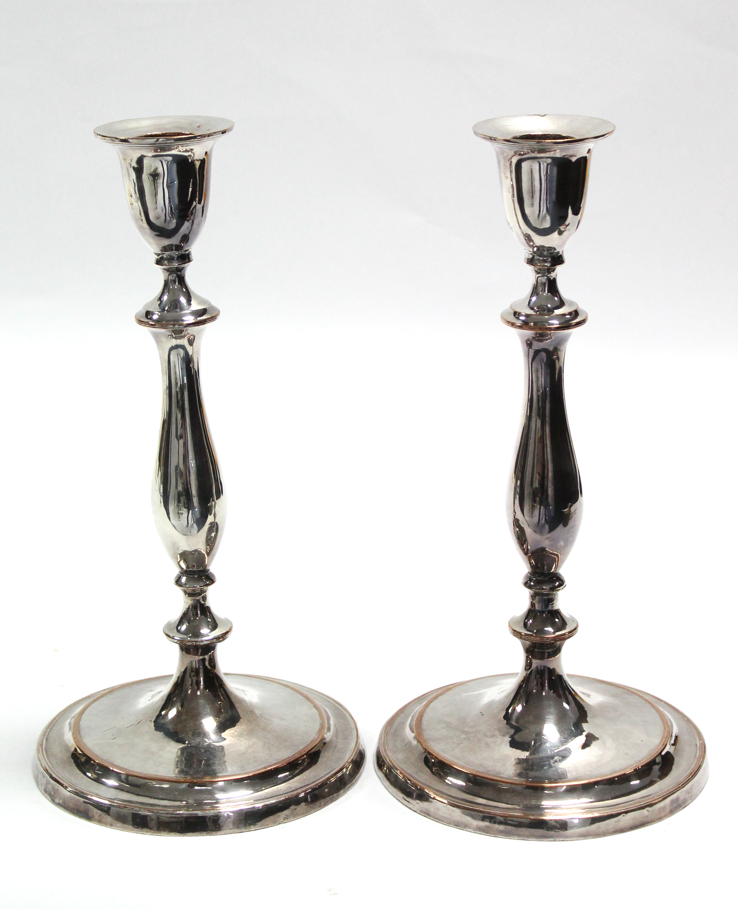 A pair of late 18th century Sheffield candlesticks with vase-shaped nozzles, slender baluster