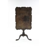 A George III-style mahogany tripod table, the rectangular top with pie-crust edge, on turned &