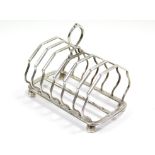 A George V six-division toast rack with centre ring handle, on four octagonal bun feet, 5¼” long;