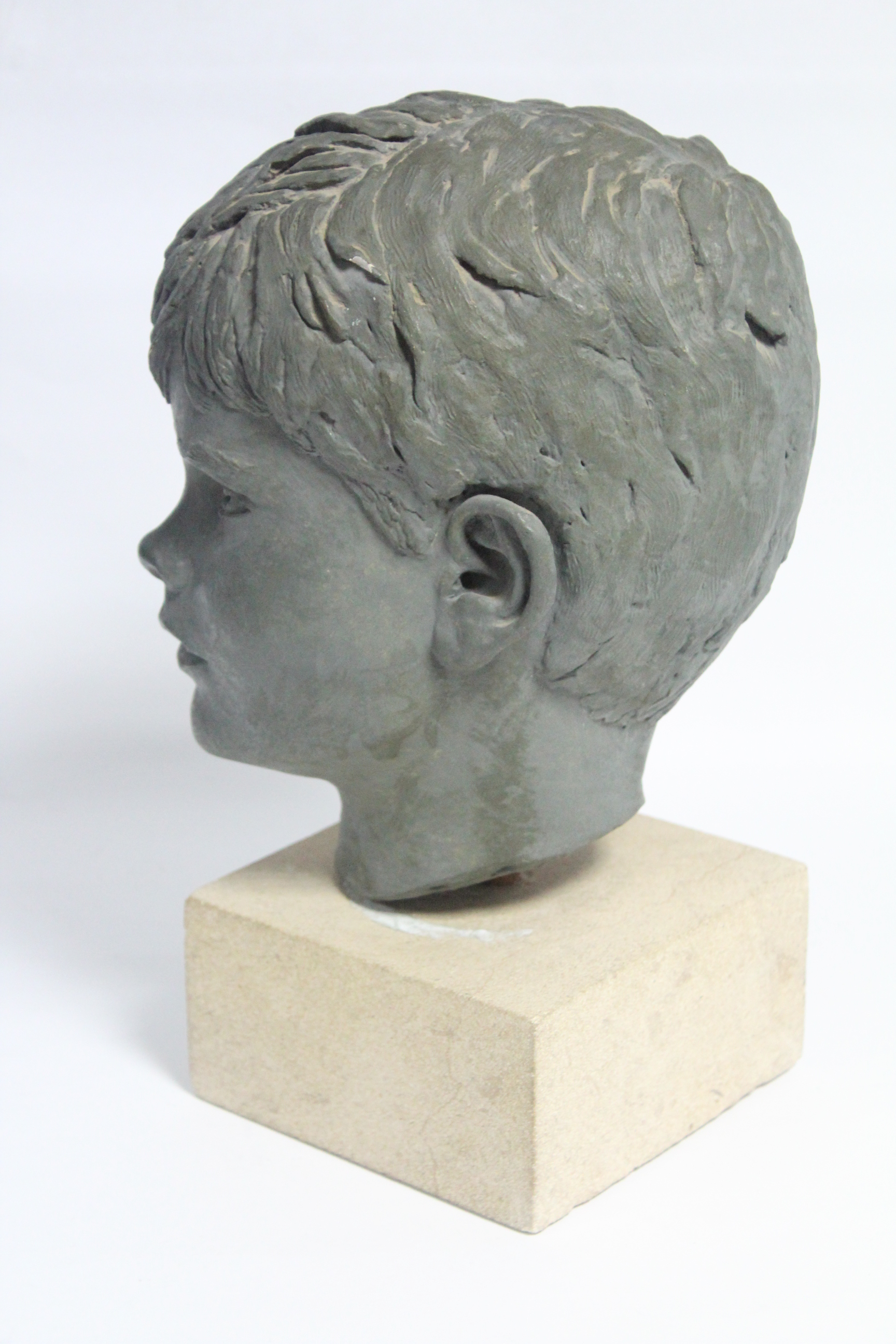 A green painted plaster head of a young boy, on stone block base; 13½” high over-all. - Image 2 of 4