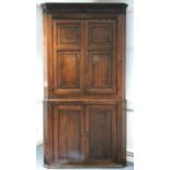 A late 18th century oak standing corner cupboard with fluted frieze below the dentil cornice, fitted