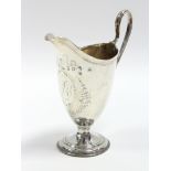 A George III helmet-shaped cream jug with engraved monogram to an oval cartouche, loop handle, &