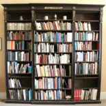 A 19th century OAK BREAK-FRONT OPEN LIBRARY BOOKCASE with applied carved giltwood flowers to the