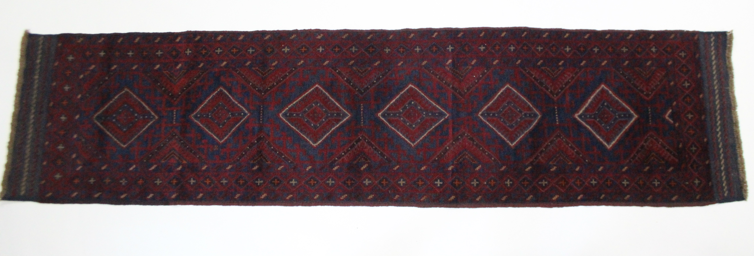 A Meshwari runner of dark blue, & red ground with all over repeating geometric lozenge design; 26" x