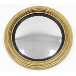 A regency convex wall mirror in reeded giltwood frame with ebonised inner slip; 25" diam.