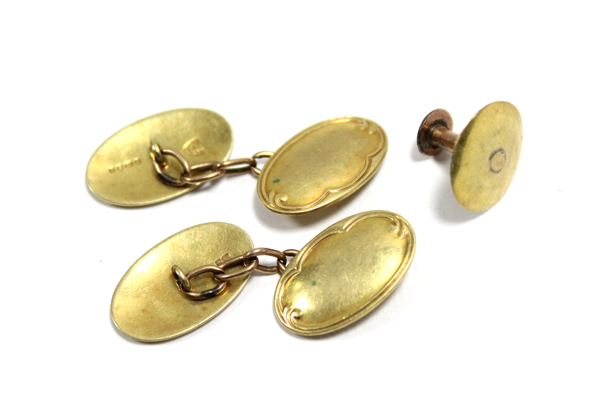 A pair of 18ct. gold cuff-links with oval panels (7.9gm); & a 15ct. gold shirt stud (1.2gm).
