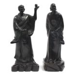 A PAIR OF CHINESE CARVED HARDWOOD STANDING FIGURES OF IMMORTALS, each dressed in long robes; 25”