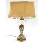 A late 19th/early 20th century table oil lamp with clear cut glass reservoir on three gilt-brass