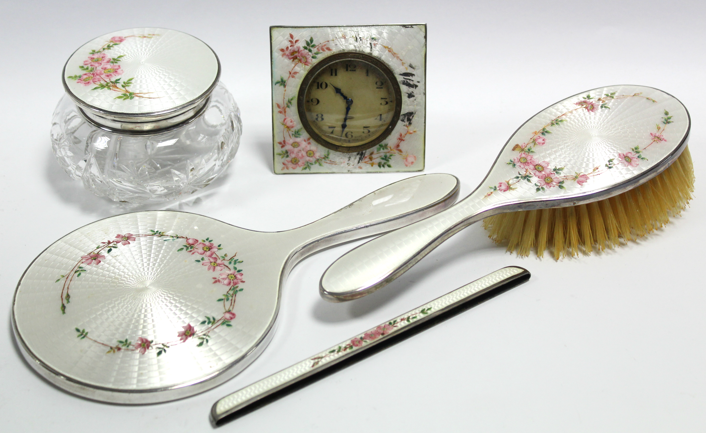 A four-piece dressing table set with guilloche enamel decoration of pink flowers on a pearl