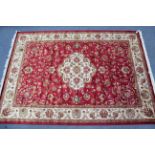 A Kashan carpet of crimson & cream ground with centre medallion & with all-over repeating