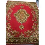 An Axminster-type Persian pattern carpet of crimson ground central medallion surrounded by floral