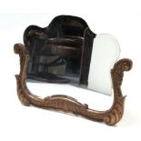 An early 20th century shaped bevelled wall mirror with gilt gesso scroll frame to the lower part,