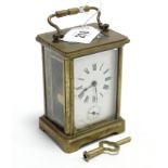 A French brass-cased carriage clock with black roman numerals to the white enamel dial, 4 ½” high.