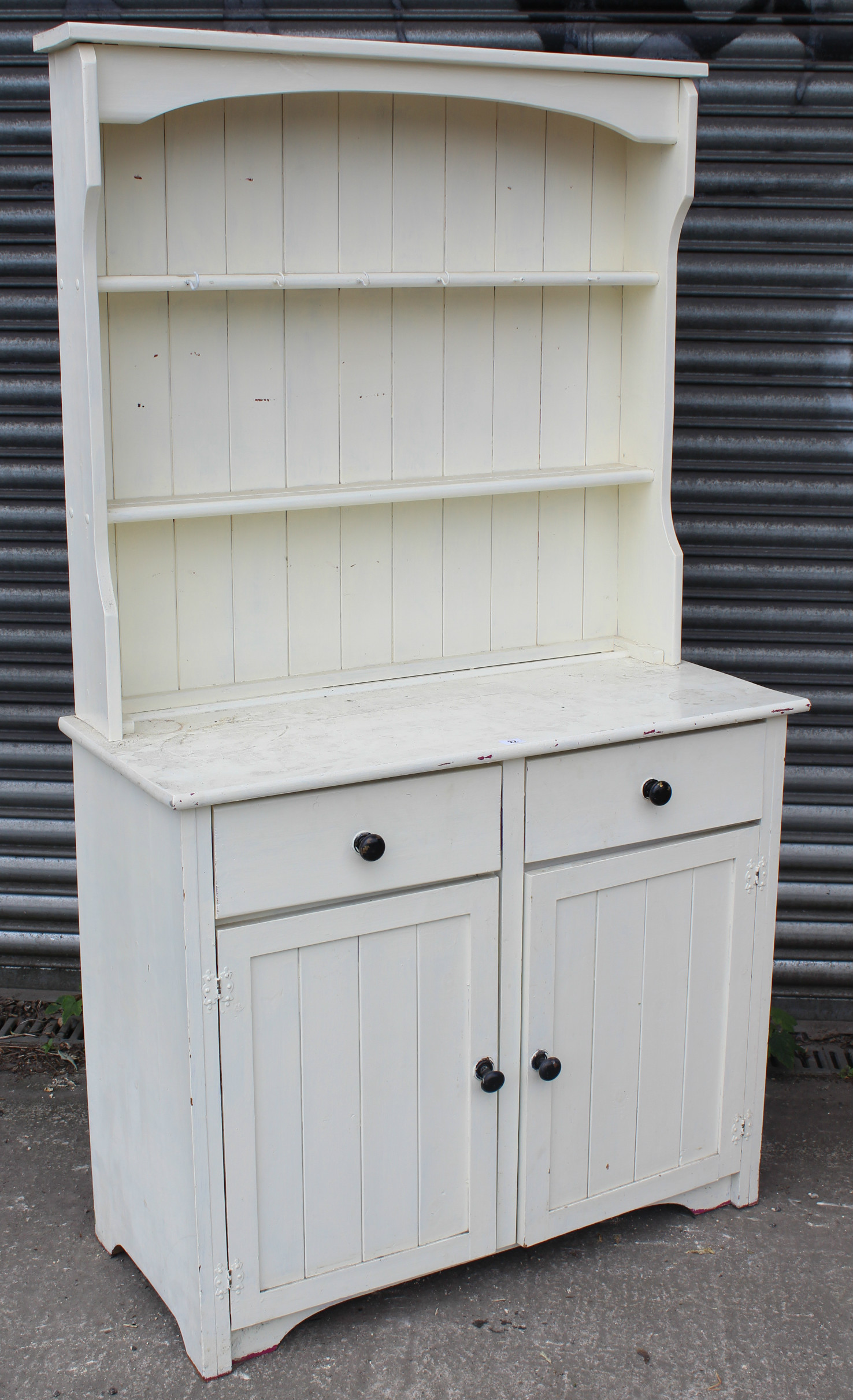 A white painted pine small dresser, the upper part fitted two open shelves & with panelled back, the