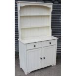 A white painted pine small dresser, the upper part fitted two open shelves & with panelled back, the