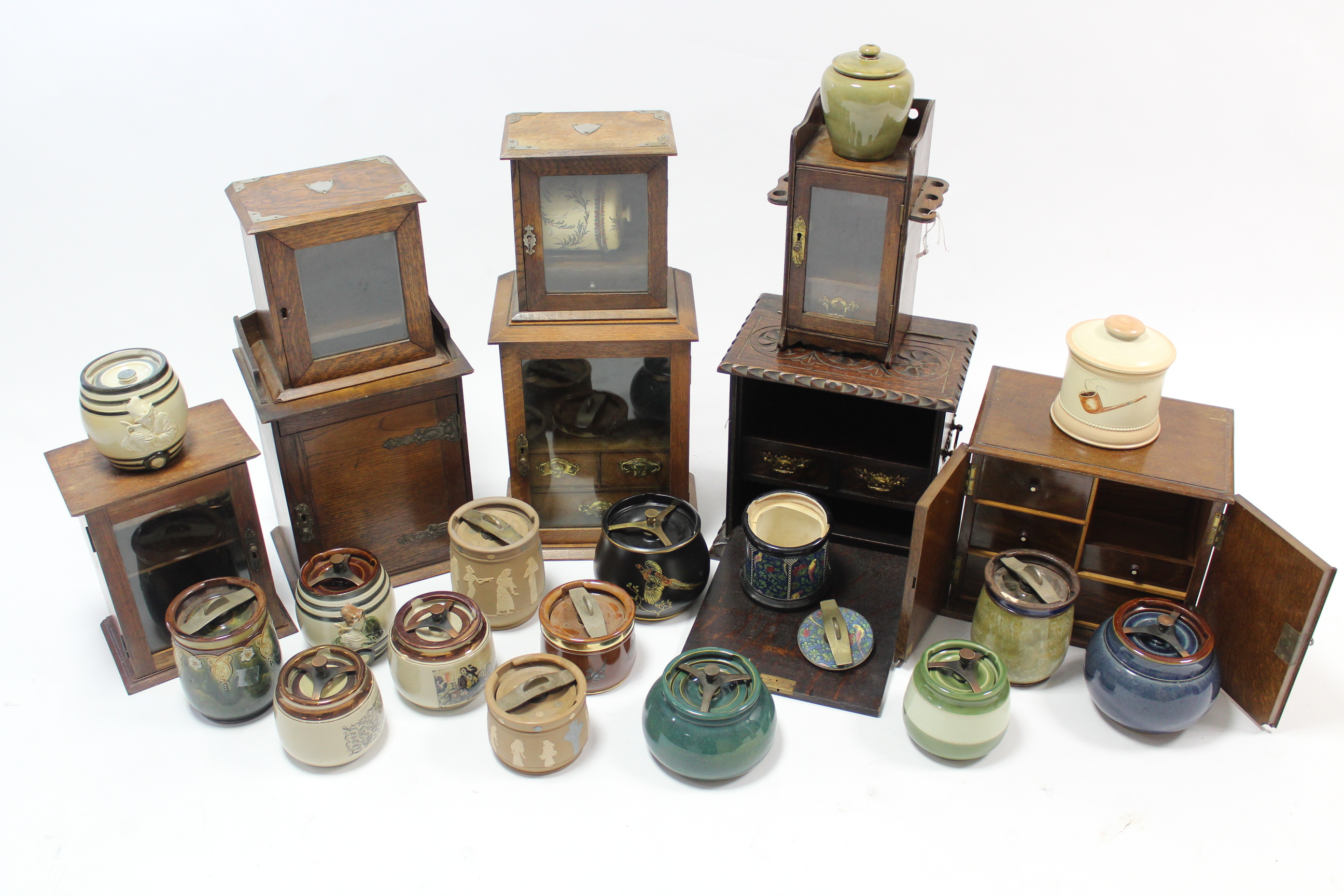 Seven various Edwardian smoker’s cabinets; & sixteen pottery tobacco jars.