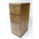 A grained pine tall filing cabinet fitted four long drawers with brass handles, & on plinth base,