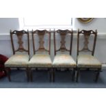 A set of four Edwardian carved oak splat-back dining chairs with padded seats, & on turned tapered