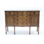 A mahogany small serpentine-front sideboard, fitted four long graduated drawers to centre flanked by