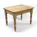 A pine kitchen table with rounded corners to the rectangular top, & on four turned tapered legs, 40”