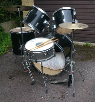 A Stagg drum kit, black finish, comprising: a 22” kick drum, a 12” tom, a 13” tom, a 16” side tom, a