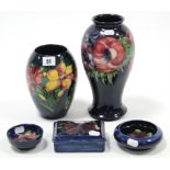 Five items of Moorcroft pottery comprising two vases; a rectangular box, & two circular dishes, each
