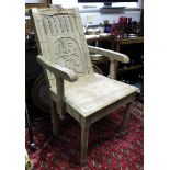 A late 19th/early 20th century master’s chair with carved panelled back, hard seat, & on ring-turned