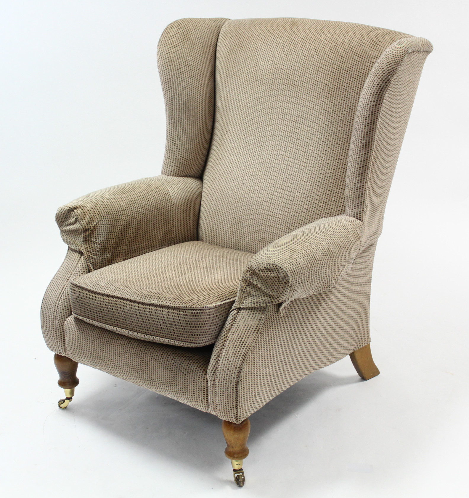 A Parker Knoll wing-back armchair upholstered fawn geometric velour, & on short turned legs with