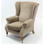 A Parker Knoll wing-back armchair upholstered fawn geometric velour, & on short turned legs with