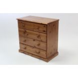 A pine small chest fitted for long drawers with turned knob handles, & on shaped plinth base, 31½”
