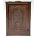 *LOT WITHDRAWN* A late 18th century oak corner cupboard, the fielded panel door carved with vine