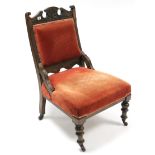 A late Victorian carved beech frame ladies' armchair, with padded seat & back upholstered crimson
