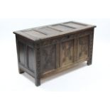 A late 17th century oak coffer, the four-panel front with later carved floral decoration, with