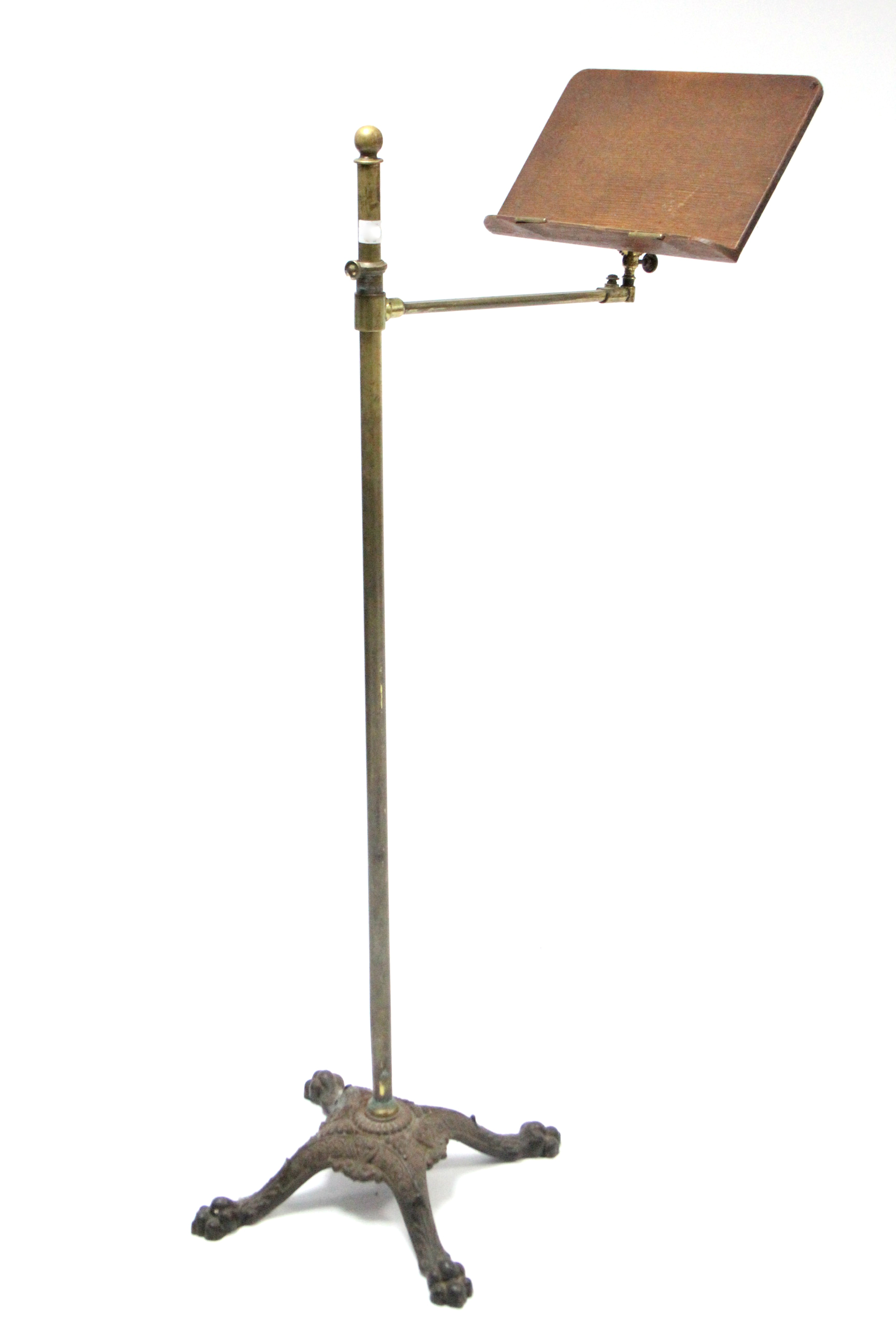 An Edwardian brass & oak adjustable reading stand on cast-iron base with four shaped legs.
